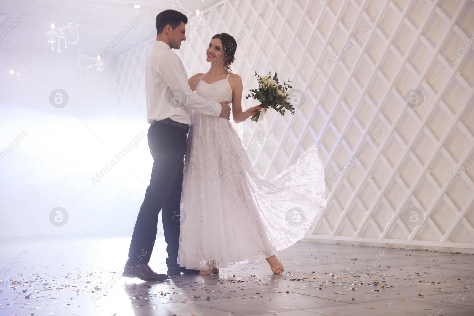 Photo of Happy newlywed couple dancing together in festive hall