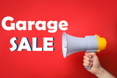 Image of Man holding megaphone and phrase GARAGE SALE on red background, closeup