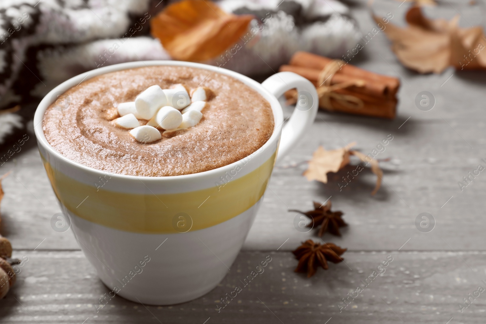 Photo of Cup of hot drink on grey wooden table, closeup. Cozy autumn atmosphere