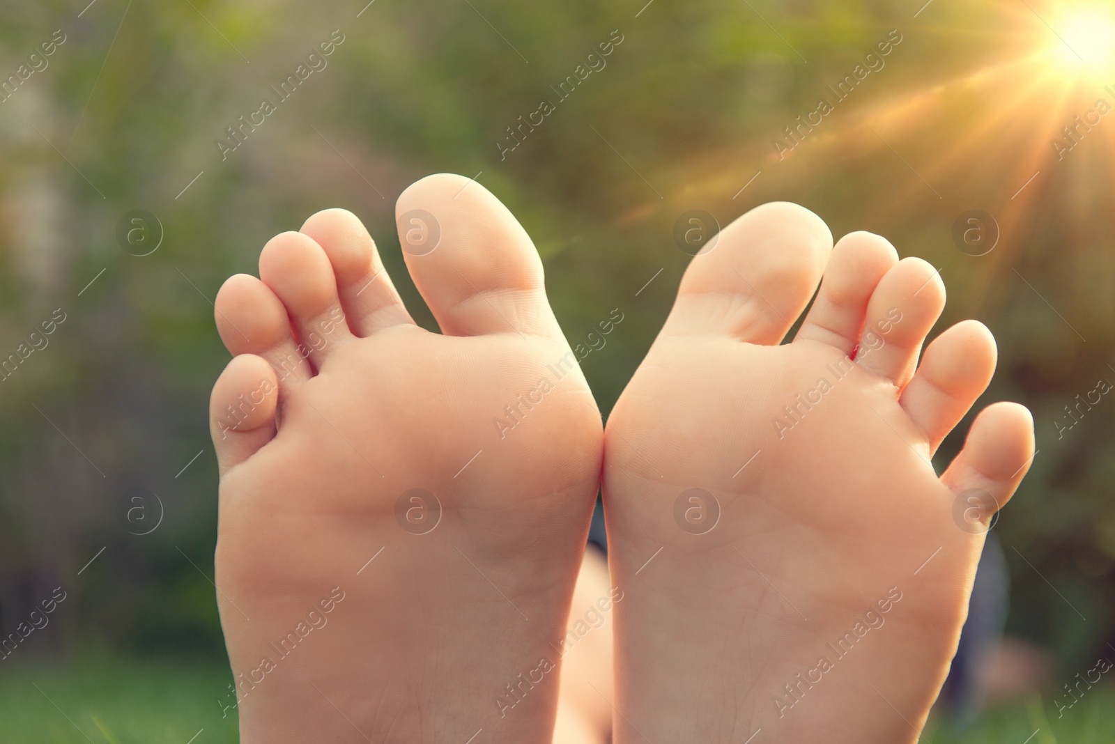 Photo of Teenage girl sitting barefoot outdoors, closeup view