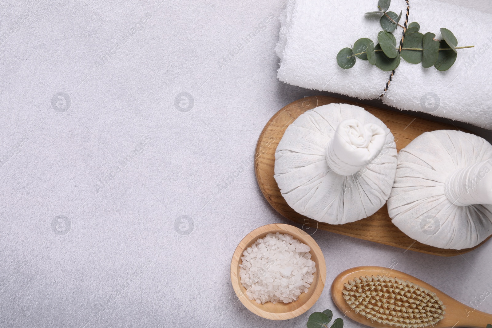 Photo of Flat lay composition with spa products and eucalyptus branches on grey table. Space for text