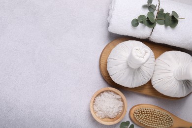 Flat lay composition with spa products and eucalyptus branches on grey table. Space for text