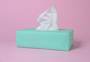 Photo of Box with paper tissues on pink background