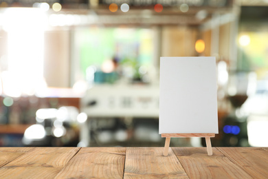 Image of Blank small board on wooden table in cafe, mockup for menu design