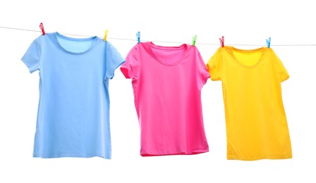 Photo of Colorful t-shirts drying on washing line isolated on white