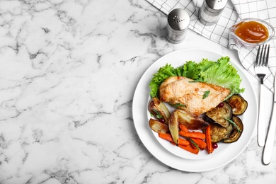Delicious cooked chicken and vegetables served on white marble table, flat lay with space for text. Healthy meals from air fryer
