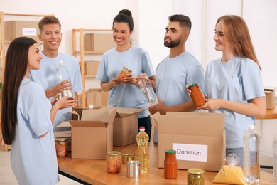 Photo of Group of volunteers packing food products in warehouse