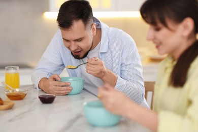 Photo of Happy couple having tasty breakfast at home, selective focus
