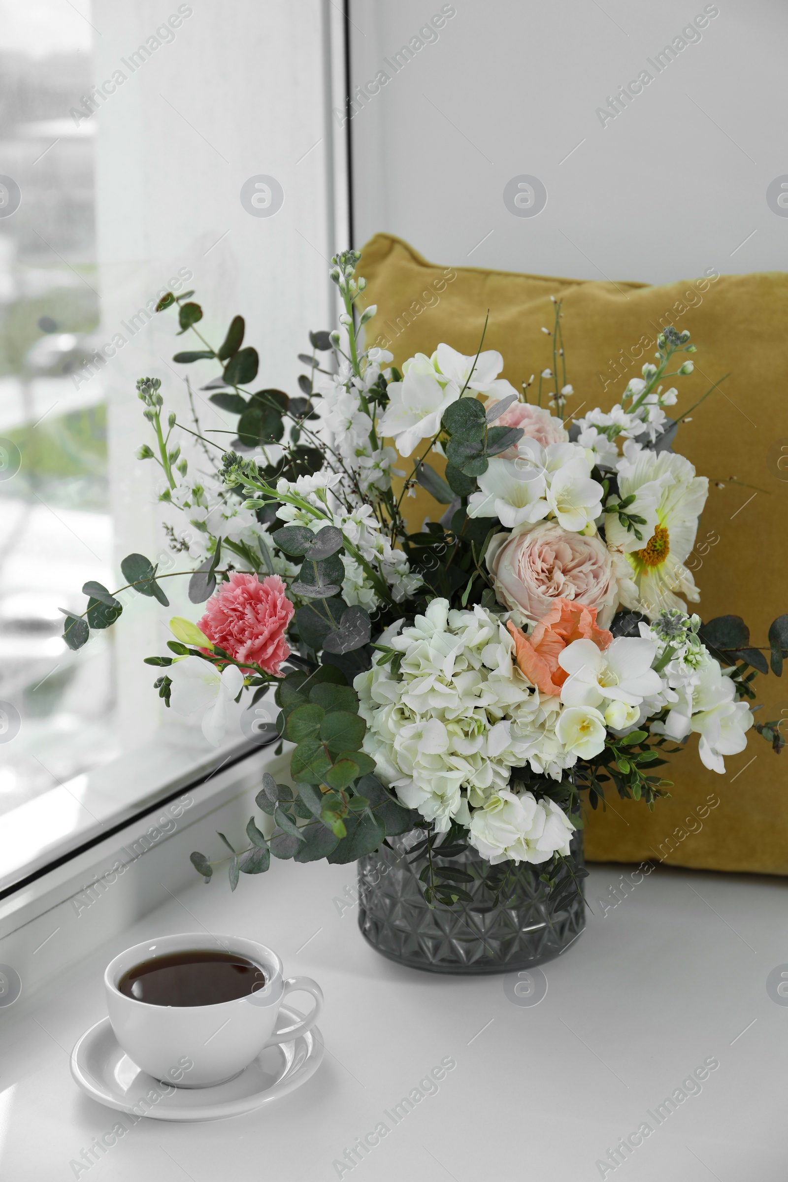 Photo of Bouquet of beautiful flowers and coffee on windowsill