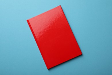 Photo of New red planner on light blue background, top view
