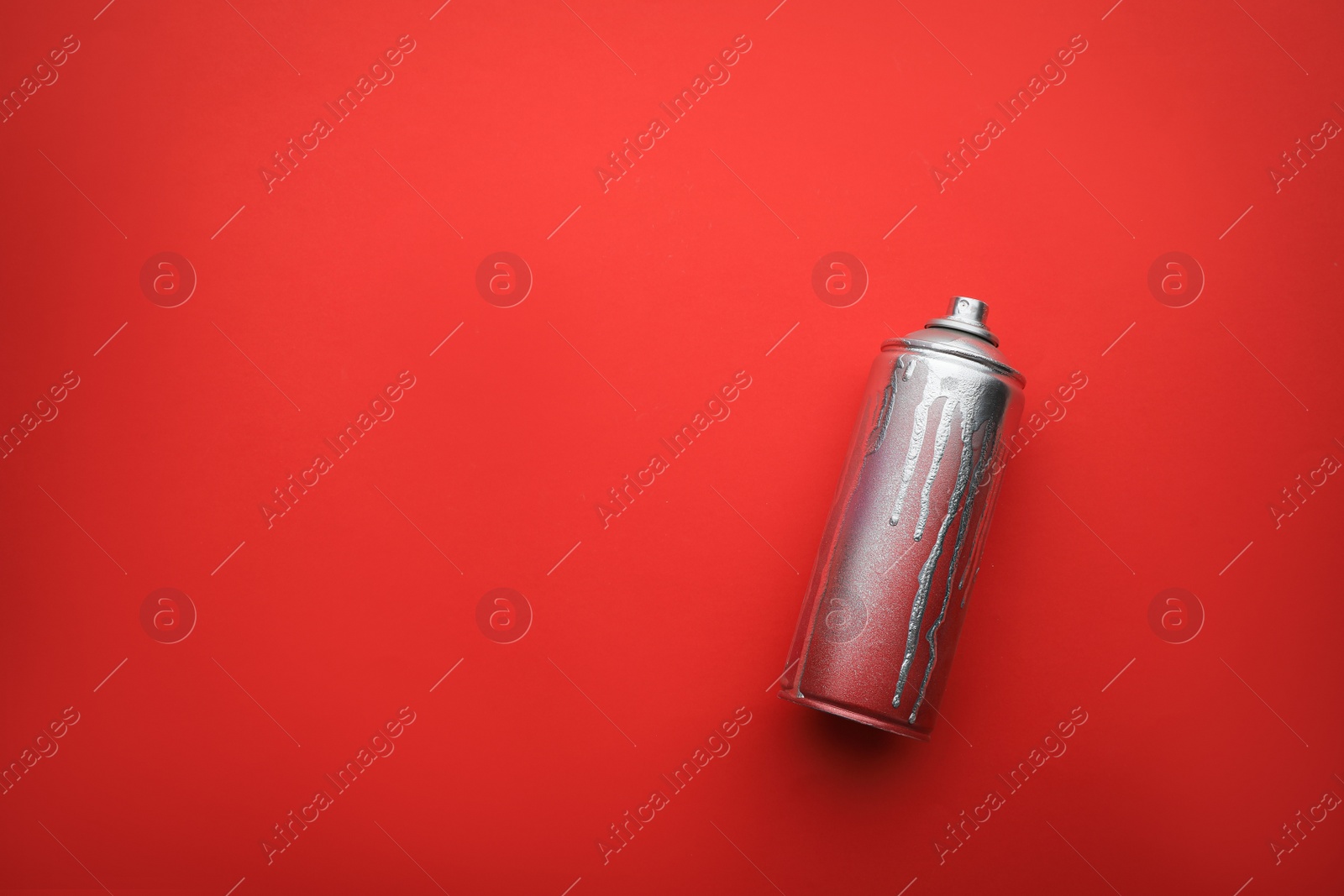 Photo of Used can of spray paint on red background, top view with space for text. Graffiti supply