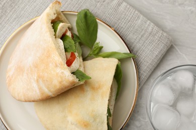 Photo of Delicious pita sandwiches with mozzarella, tomatoes and basil on light grey marble table, flat lay
