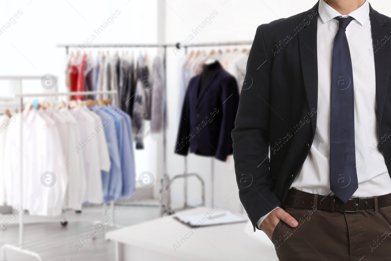 Image of Businessman and blurred view of dry-cleaner's interior, closeup. Space for text 