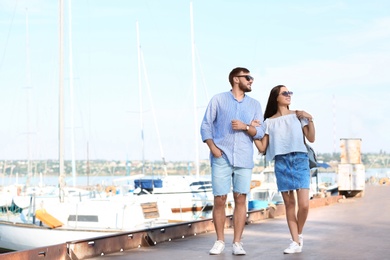 Photo of Young hipster couple in jean clothes on pier