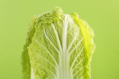 Photo of Fresh ripe Chinese cabbage on light green background, closeup