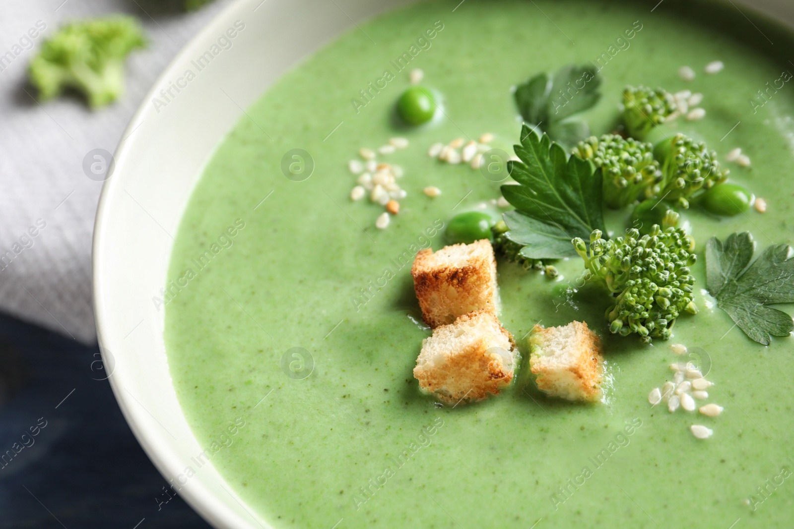 Photo of Fresh vegetable detox soup made of broccoli and green peas with croutons in dish, closeup