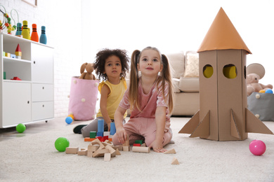 Photo of Cute little children playing with blocks at home