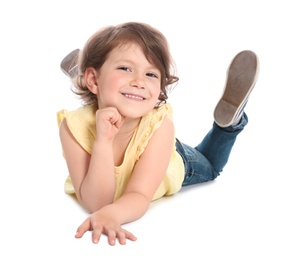 Happy little girl in casual outfit lying on white background