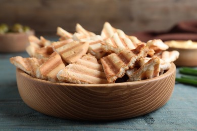 Photo of Delicious pita chips on blue wooden table, closeup