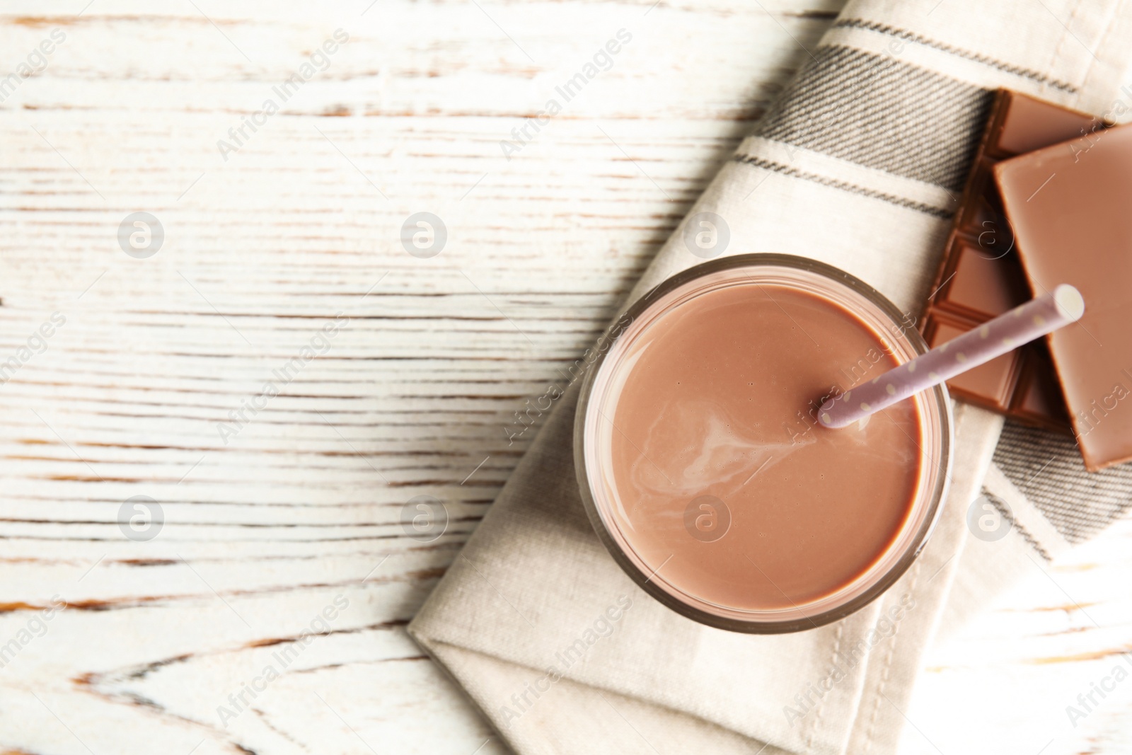 Photo of Flat lay composition with glass of tasty chocolate milk and space for text on wooden background. Dairy drink