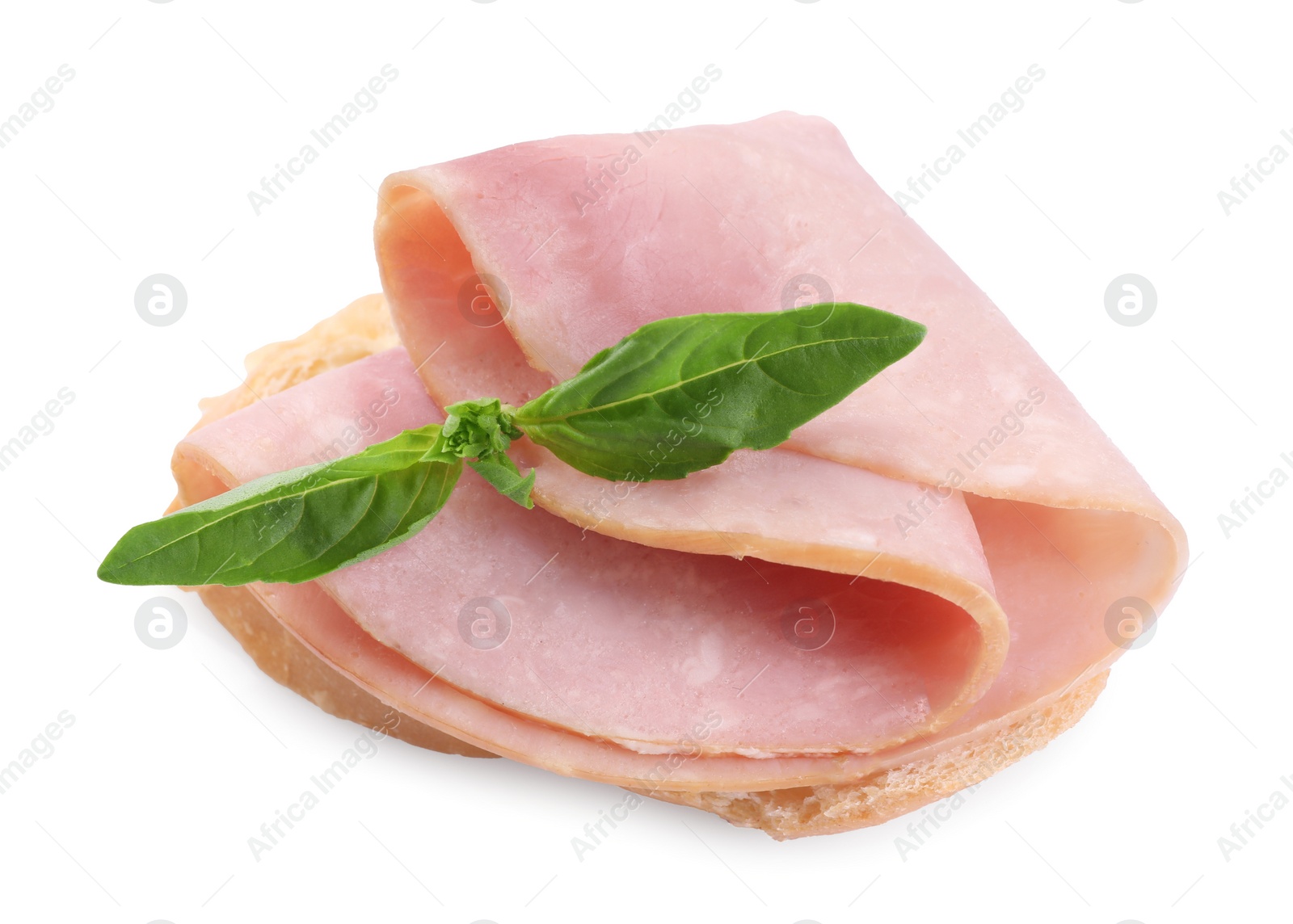 Photo of Piece of bread with tasty ham slice and basil isolated on white