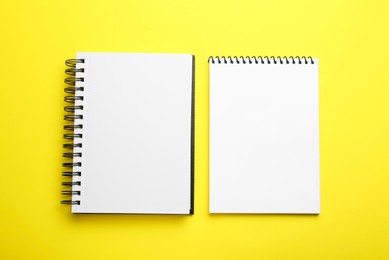 Notebooks on yellow background, top view. Space for text
