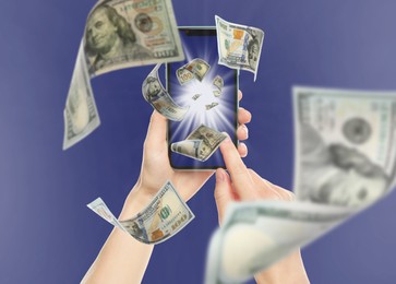 Online wallet. Woman using mobile phone on blue background, closeup. Dollar banknotes flying from device screen