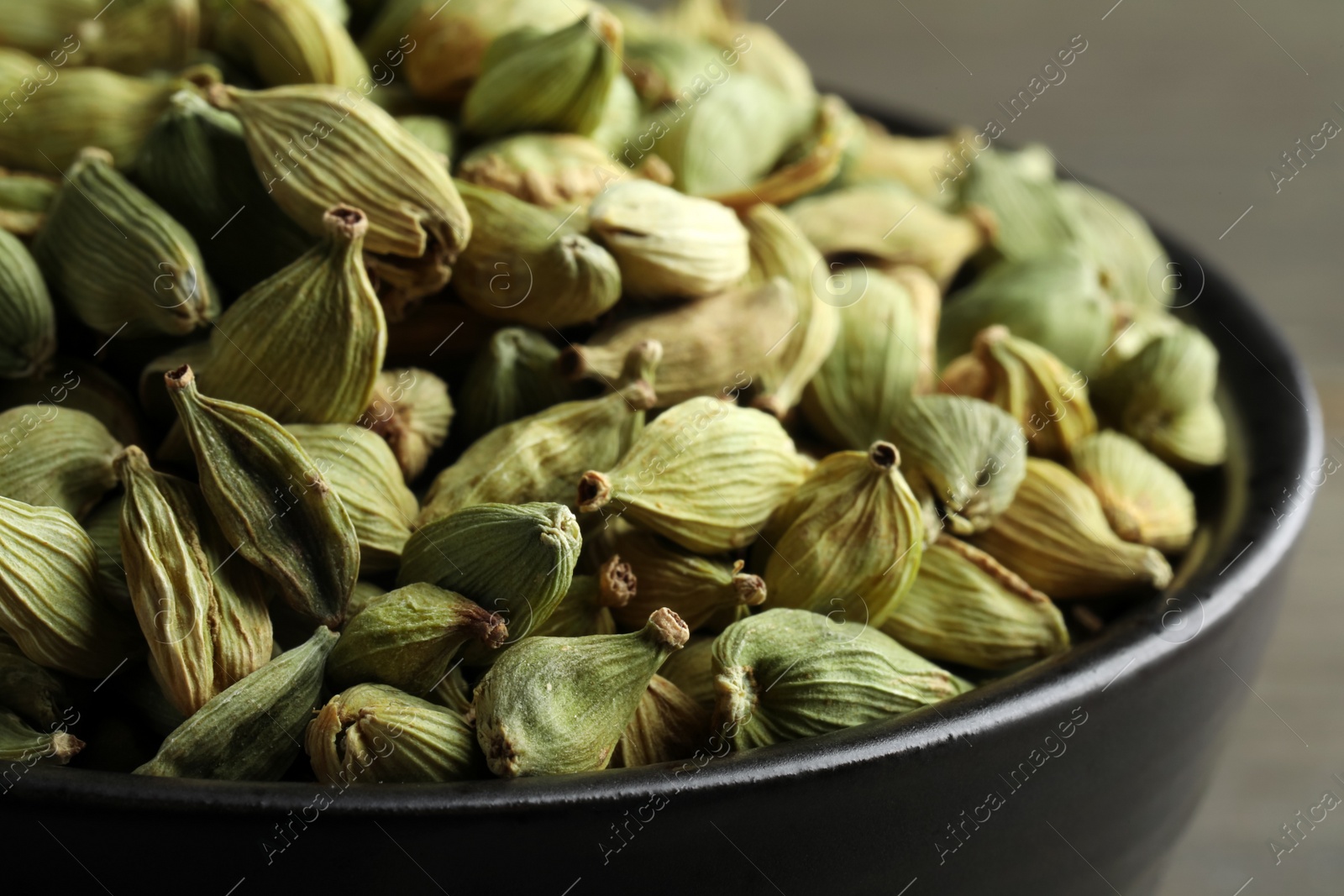 Photo of Bowl of dry cardamom pods, closeup view