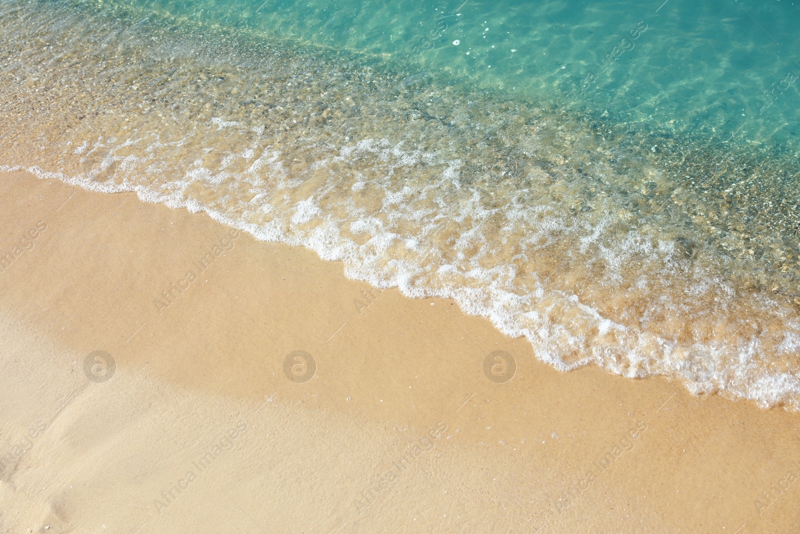 Photo of View of sea water and beach sand on sunny day