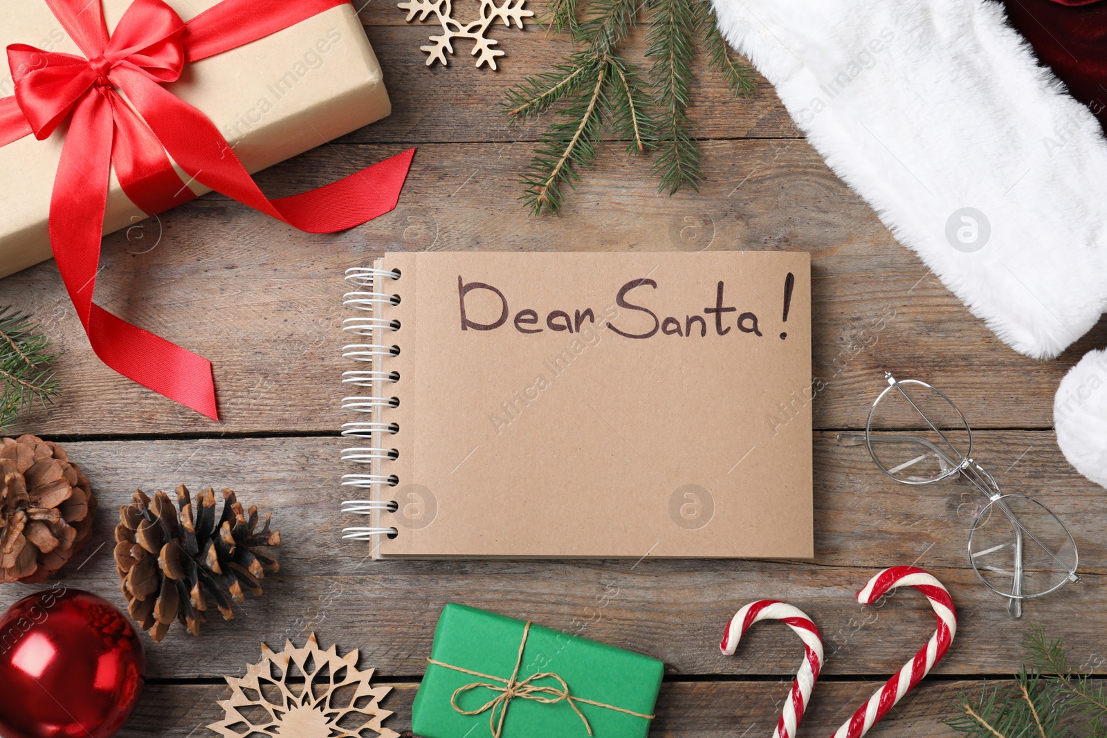 Photo of Notebook with title Dear Santa and Christmas decor on wooden background, flat lay