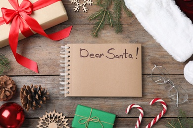 Photo of Notebook with title Dear Santa and Christmas decor on wooden background, flat lay