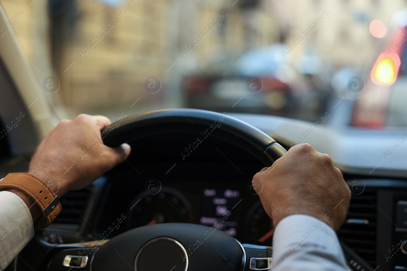 Photo of Stuck in traffic jam. Driver holding hands on steering wheel in car, closeup