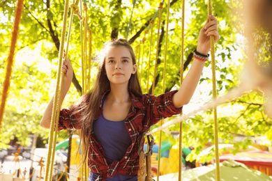 Photo of Teenage girl climbing in adventure park. Summer camp