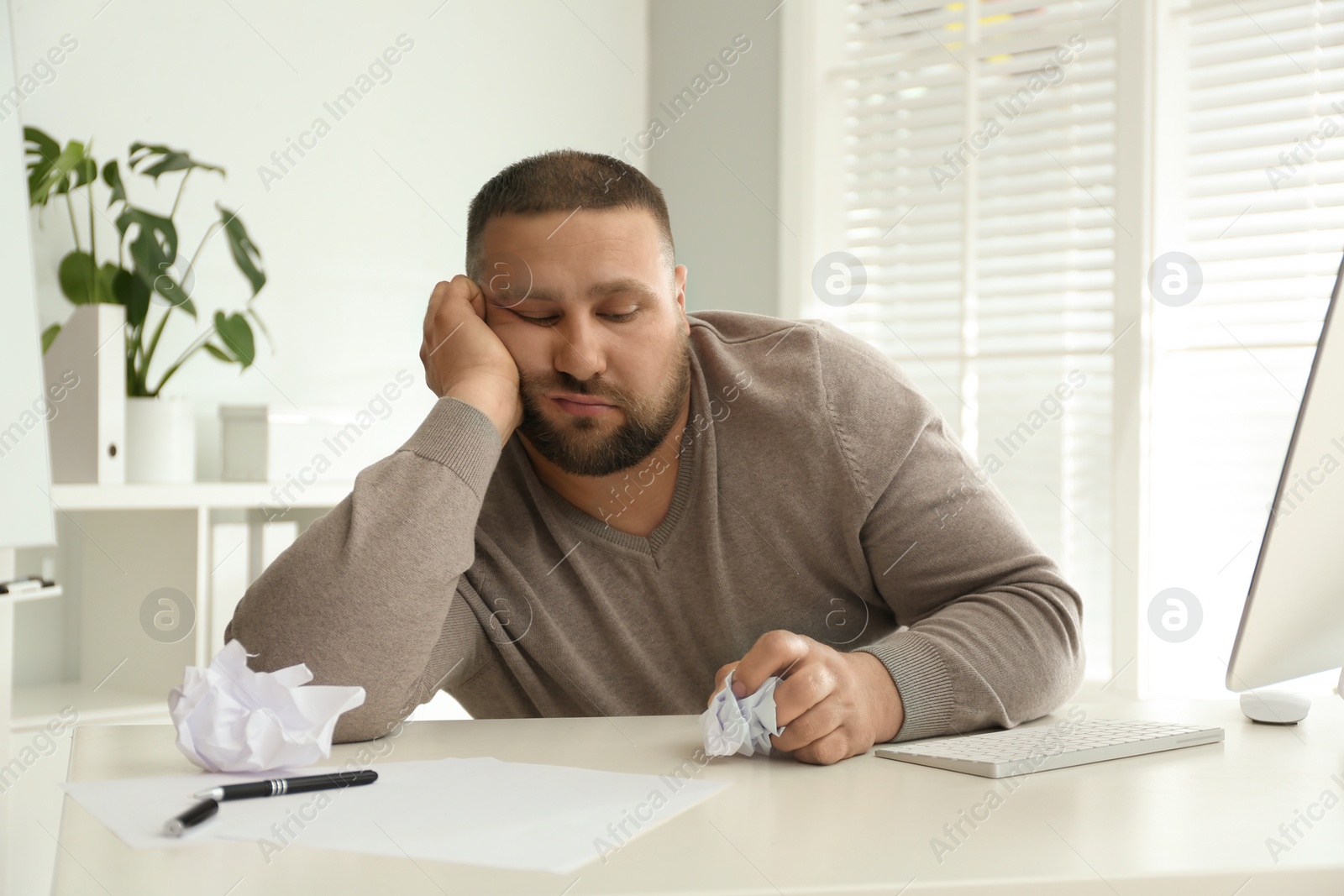 Photo of Lazy overweight office employee procrastinating at workplace