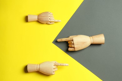 Wooden mannequin hands on color background, flat lay