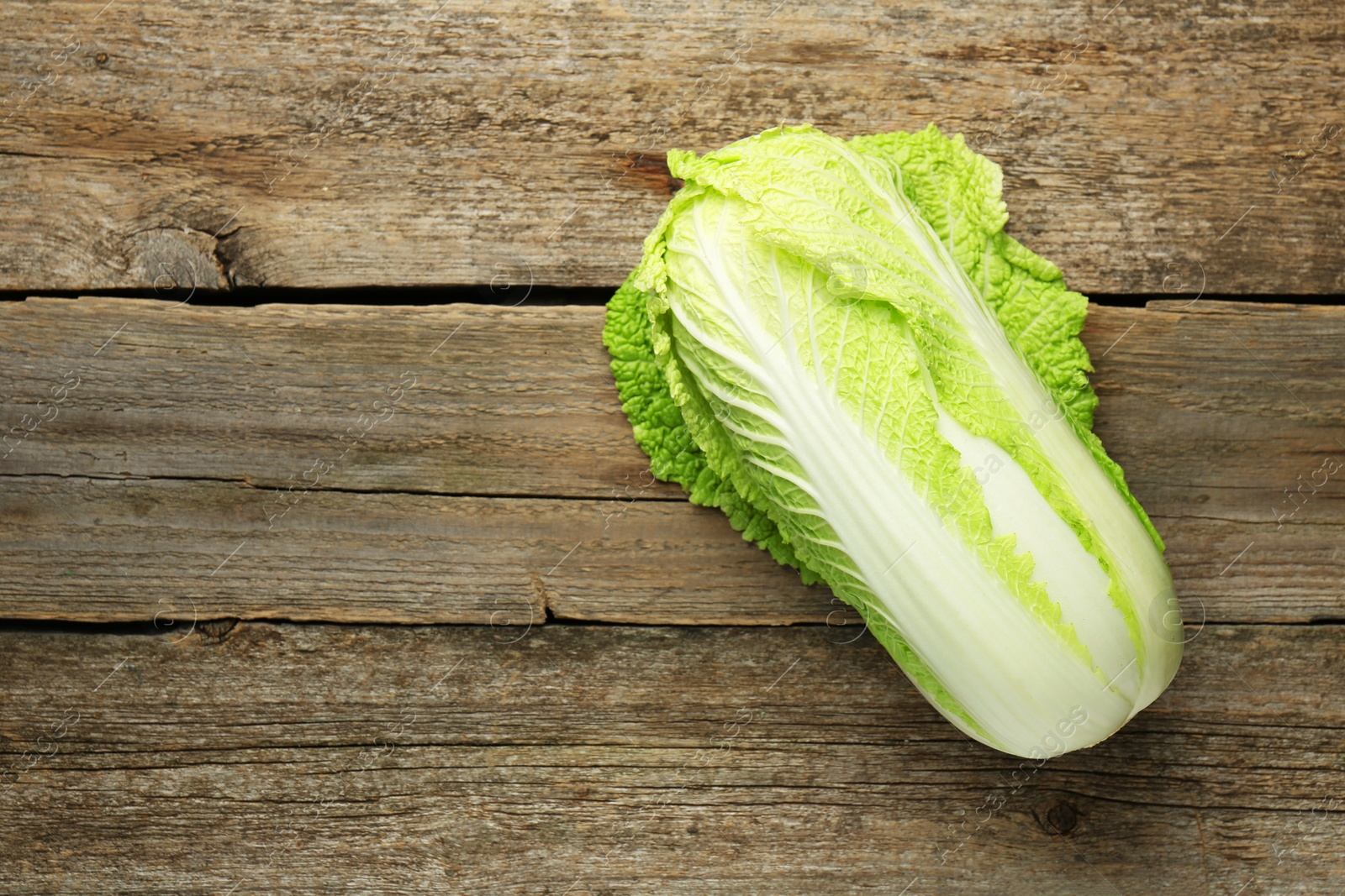 Photo of Fresh ripe Chinese cabbage on wooden table, top view. Space for text