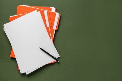 Orange files with blank sheets of paper and pen on dark green background, top view. Space for text