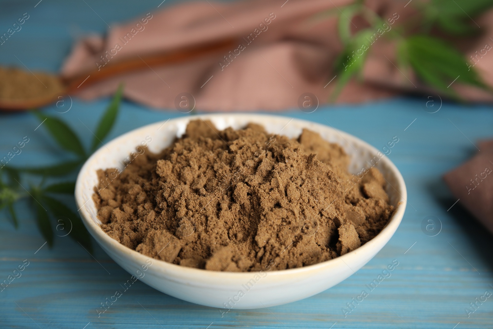 Photo of Hemp protein powder on light blue wooden table, closeup