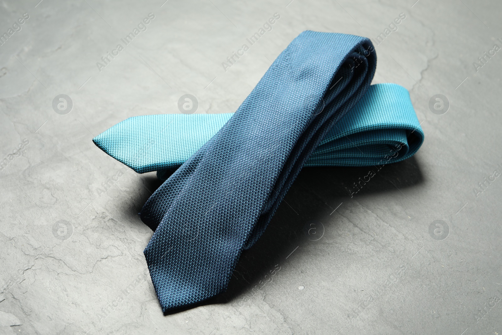 Photo of Two neckties on grey textured background, closeup