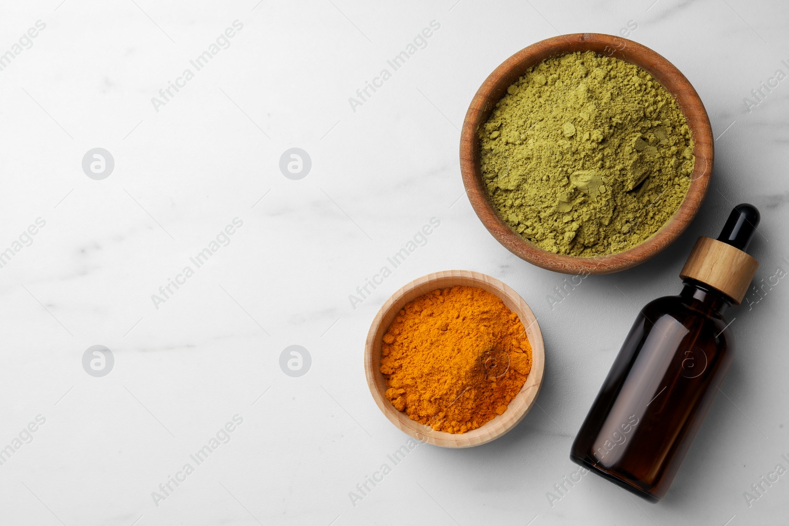 Photo of Bottle, henna and turmeric powder on white marble table, flat lay. Space for text