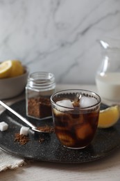 Photo of Refreshing iced coffee in glass on white wooden table