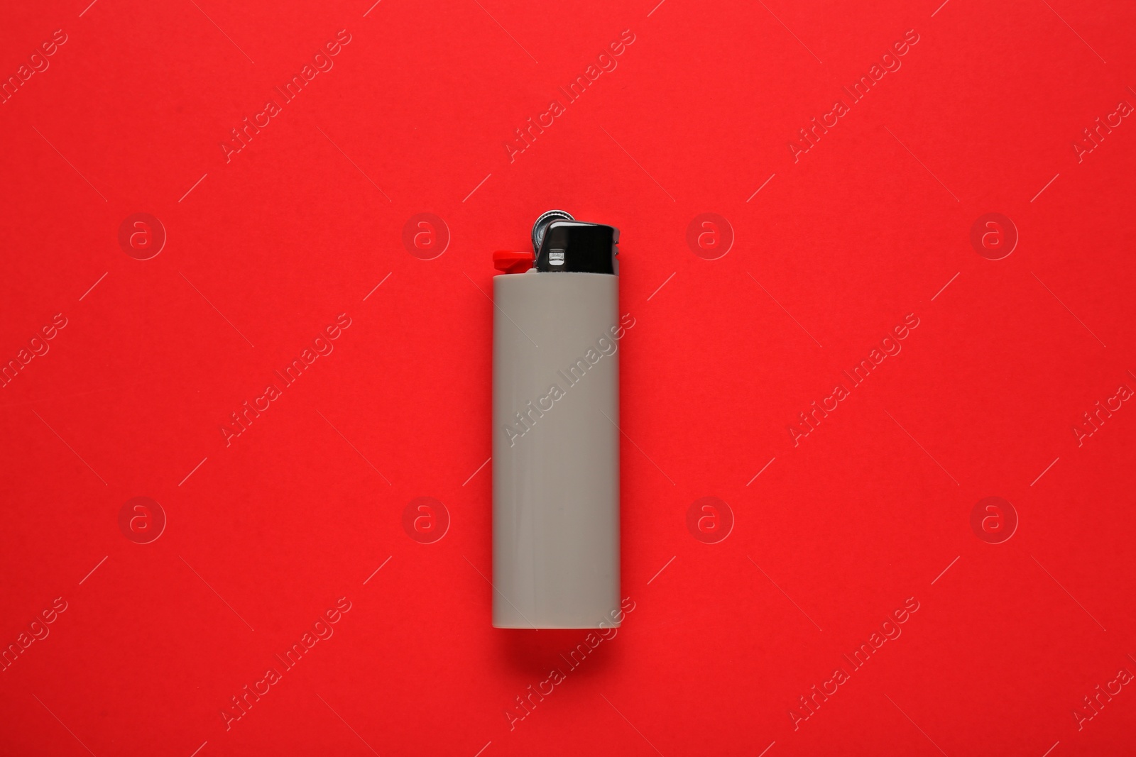 Photo of Stylish small pocket lighter on red background, top view