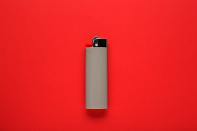 Photo of Stylish small pocket lighter on red background, top view