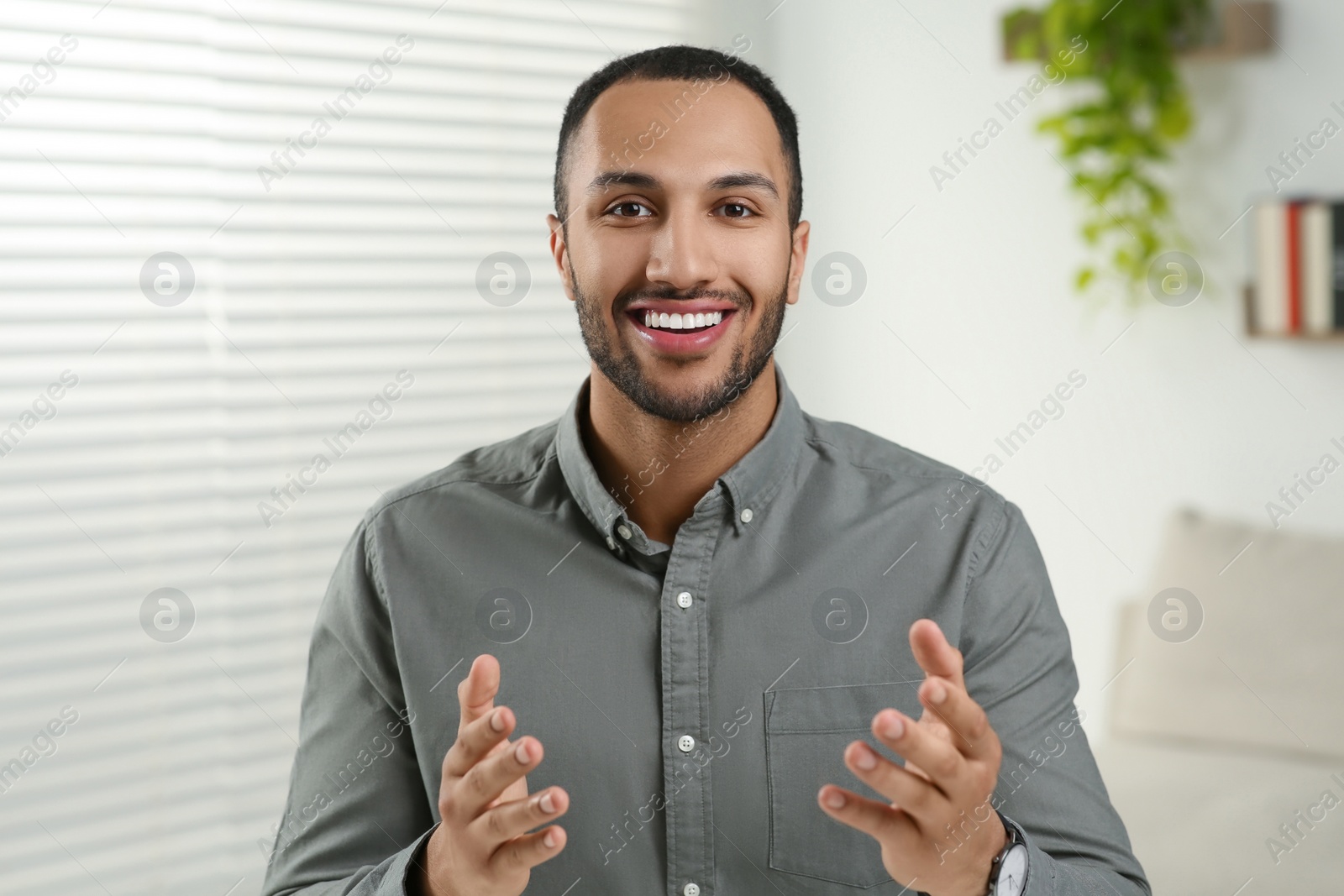 Photo of Young man having online video call at home, view from camera