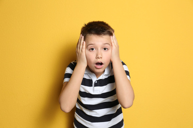 Photo of Portrait of emotional preteen boy on yellow background