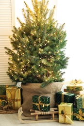 Photo of Many different gifts under Christmas tree indoors