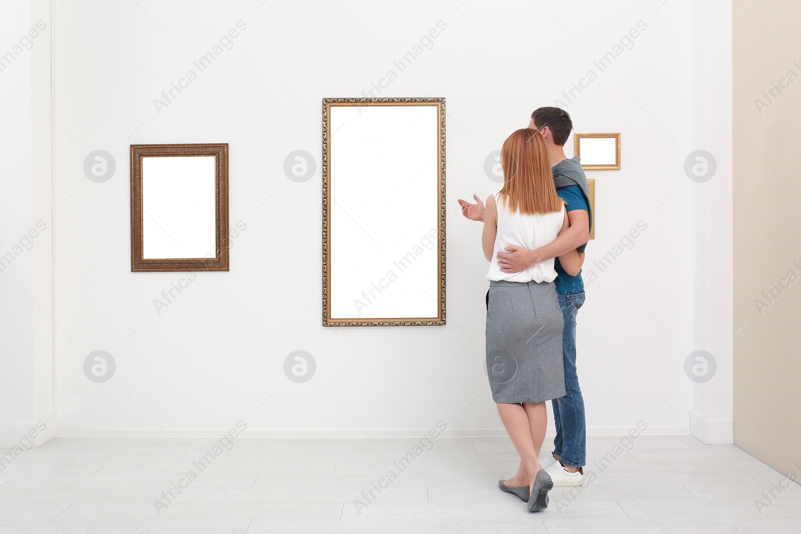 Photo of Couple viewing exposition in modern art gallery