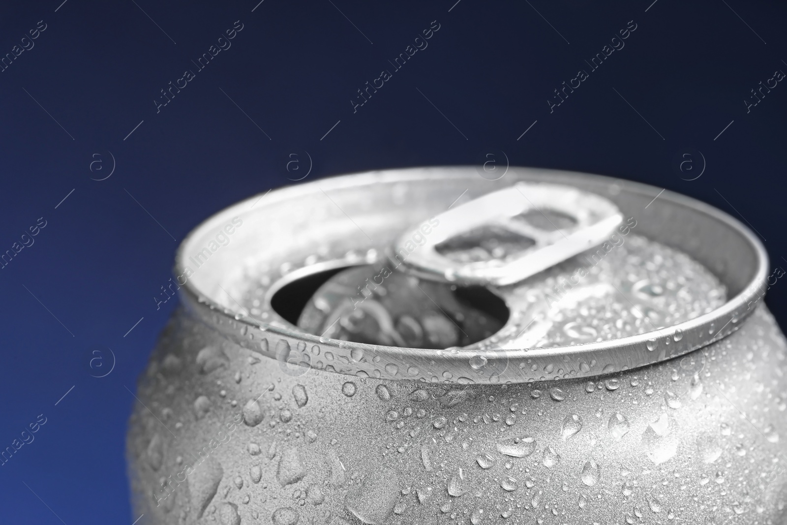 Photo of Wet open can on blue background, closeup