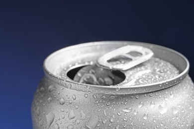 Wet open can on blue background, closeup