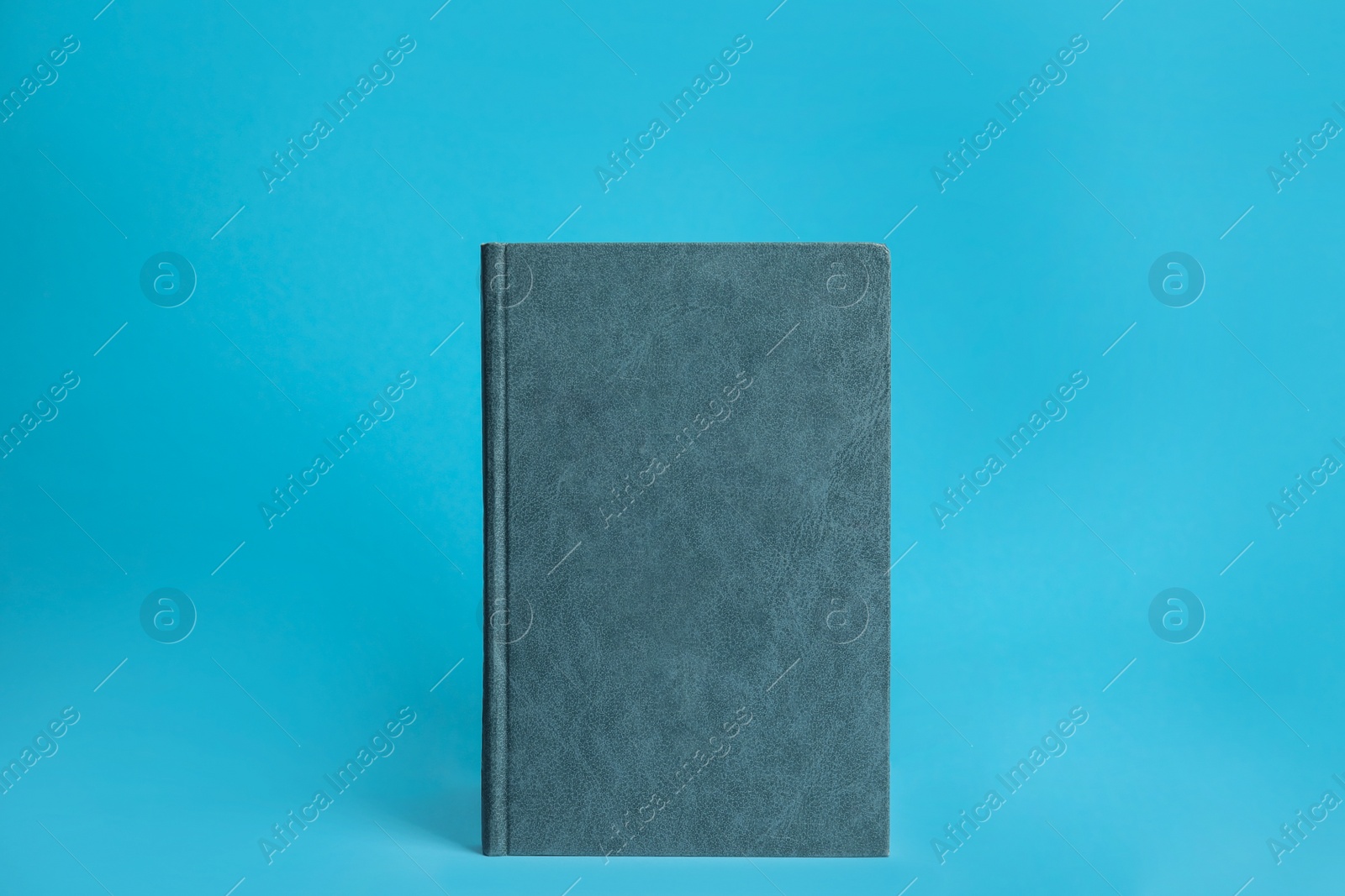 Photo of Hardcover book on blue background. Space for design